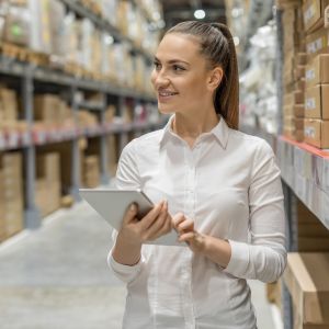 Warehouse safety inspection by a female worker using a tablet